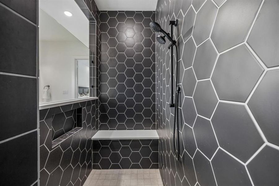 Bathroom with a tile shower and tile walls