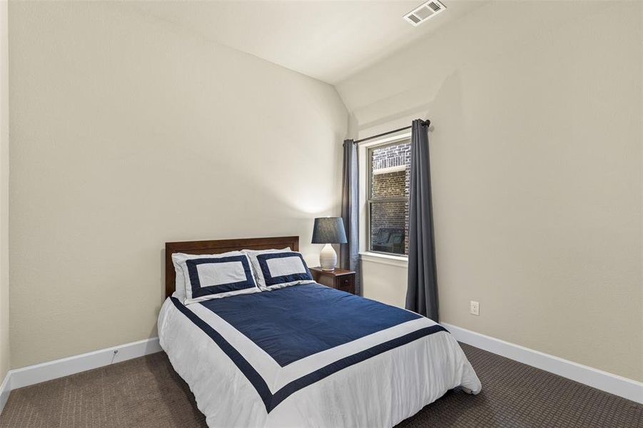 Carpeted bedroom with lofted ceiling