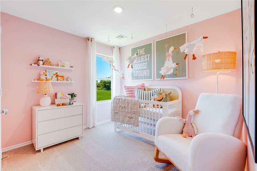 Bedroom with a crib and light carpet