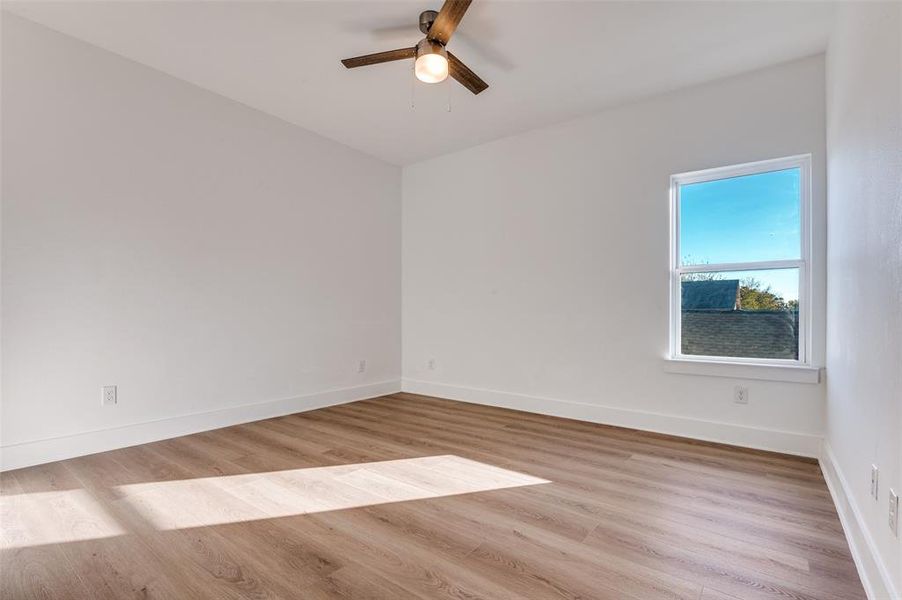 Empty room with light wood-style flooring and ceiling fan