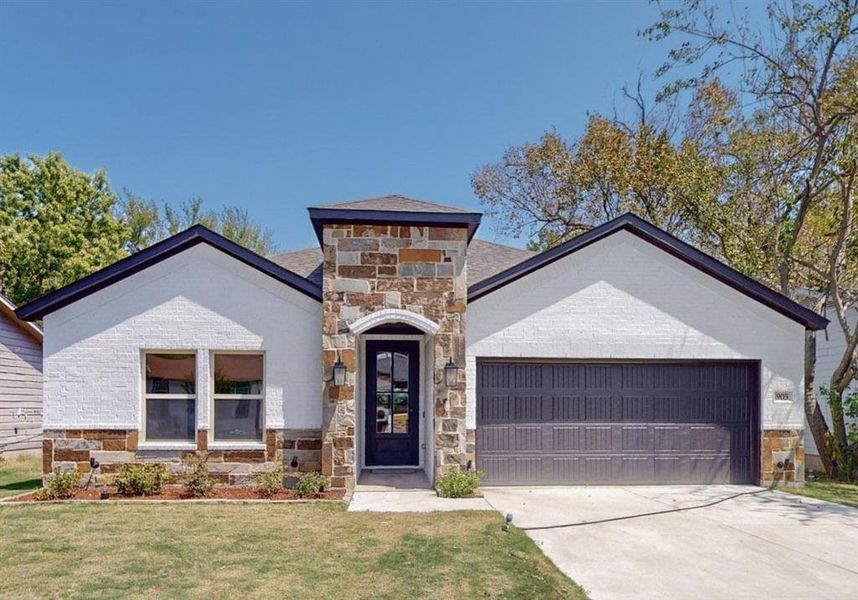 View of front of property featuring a front yard and a garage