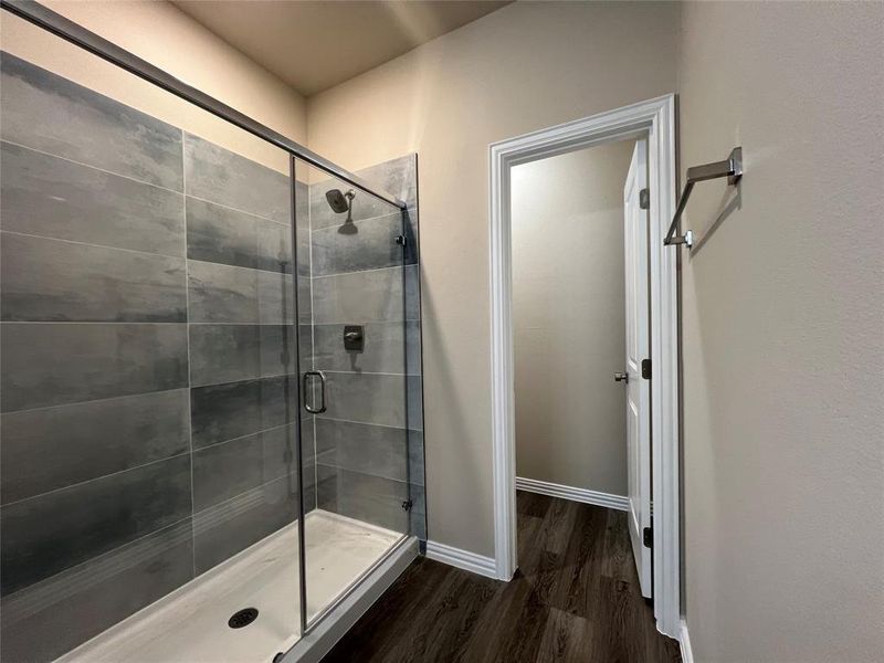 Bathroom featuring hardwood / wood-style flooring and walk in shower