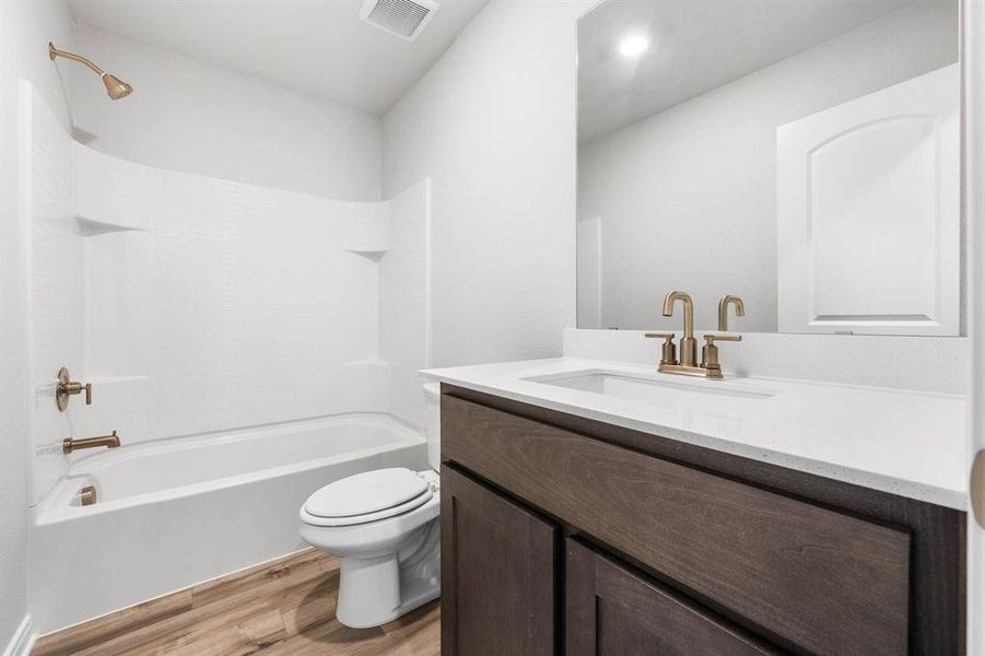 Full bathroom with shower / bath combination, hardwood / wood-style floors, toilet, and vanity