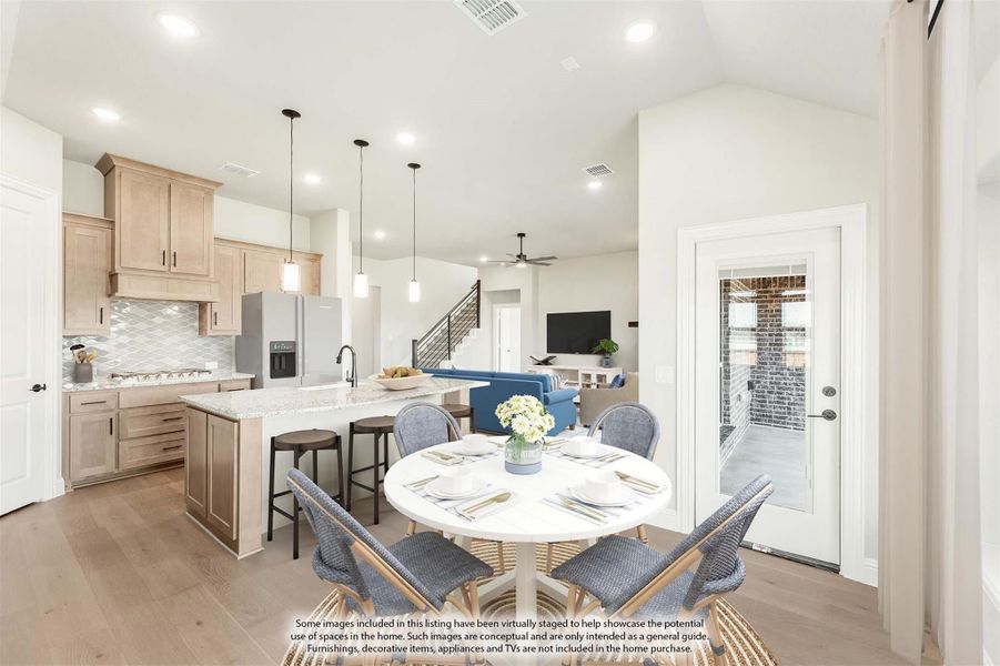 Open-concept dining area with round white table, kitchen island, light wood cabinets, and living room beyond Open-concept dining area with round white table, kitchen island, light wood cabinets, and living room beyond