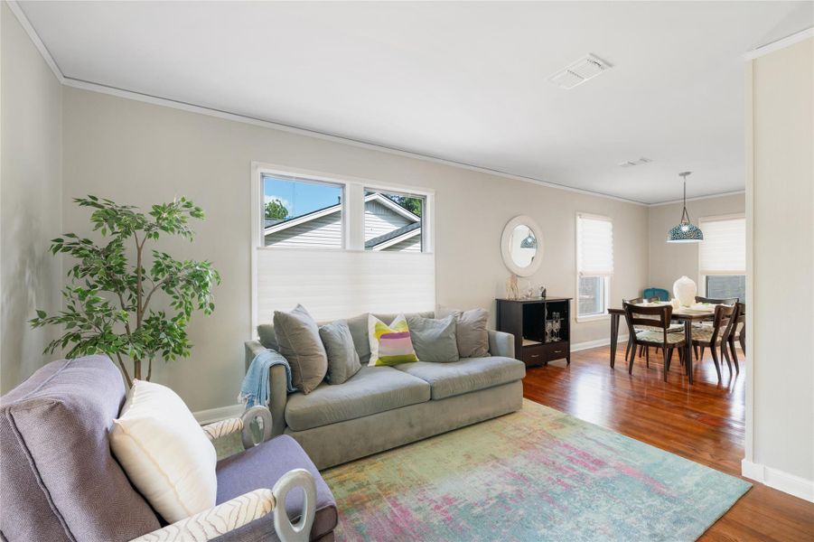 An inviting open-concept living and dining area boasts rich hardwood flooring, creating a seamless flow. An inviting open-concept living and dining area boasts rich hardwood flooring, creating a seamless flow.