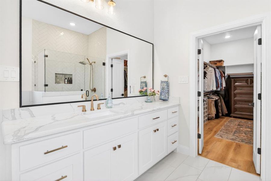 Bathroom with vanity, a shower stall, a walk in closet, light marble finish flooring, and recessed lighting Bathroom with vanity, a shower stall, a walk in closet, light marble finish flooring, and recessed lighting