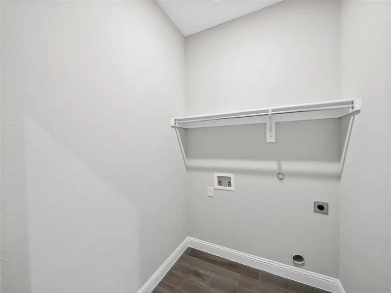 Washroom with hookup for a washing machine, hookup for an electric dryer, baseboards, gas dryer hookup, and laundry area