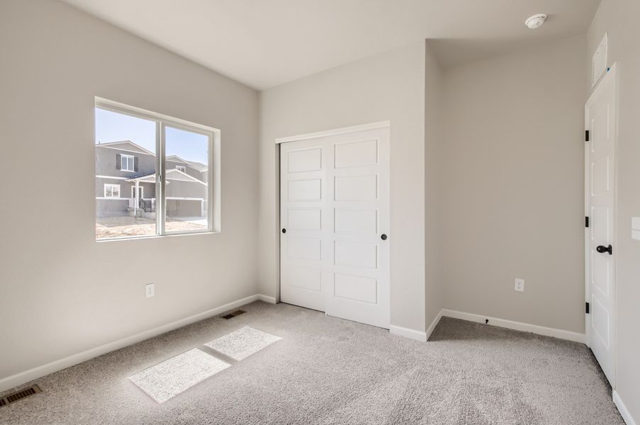 Secondary bedroom with walk in closet of the ranch style Telluride plan by Century Communities