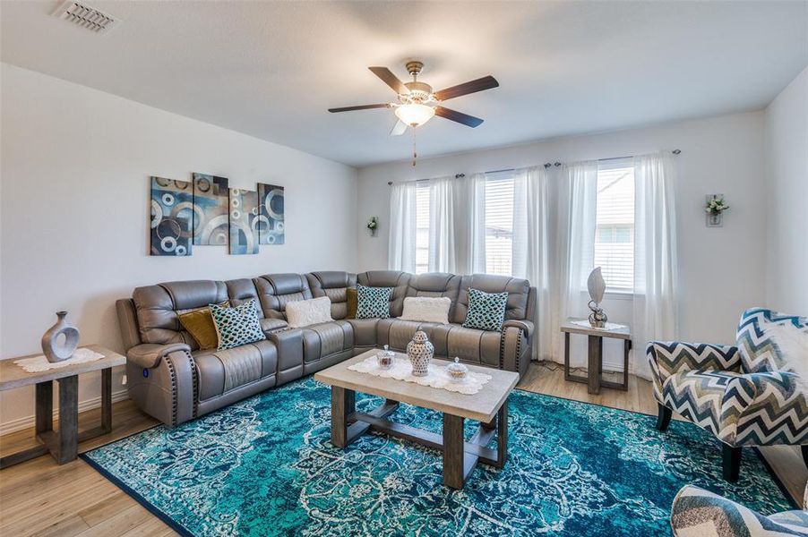 Living room featuring wood-type flooring and ceiling fan