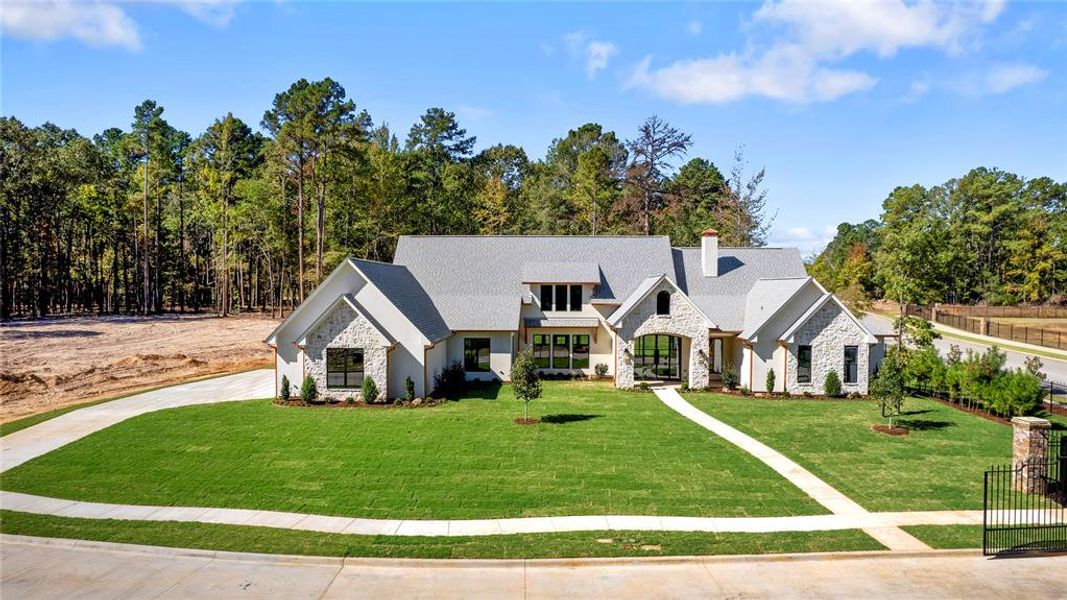 View of front of property with stone siding and a chimney