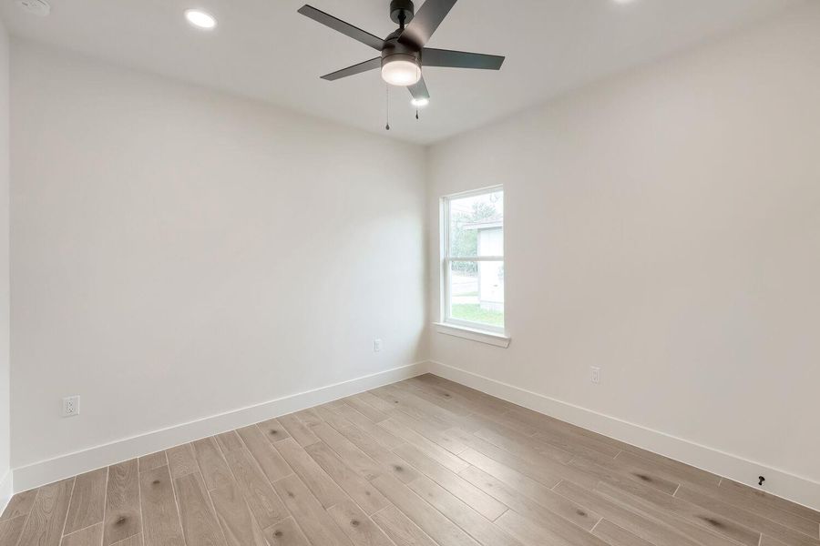 An inviting room features light wood flooring and a modern ceiling fan, offering a neutral canvas for personalization.