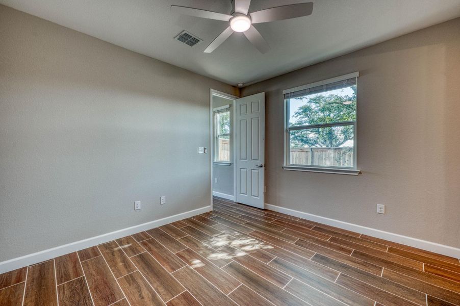 Gleaming plank flooring and natural light from a large window define this versatile secondary bedroom. Gleaming plank flooring and natural light from a large window define this versatile secondary bedroom.