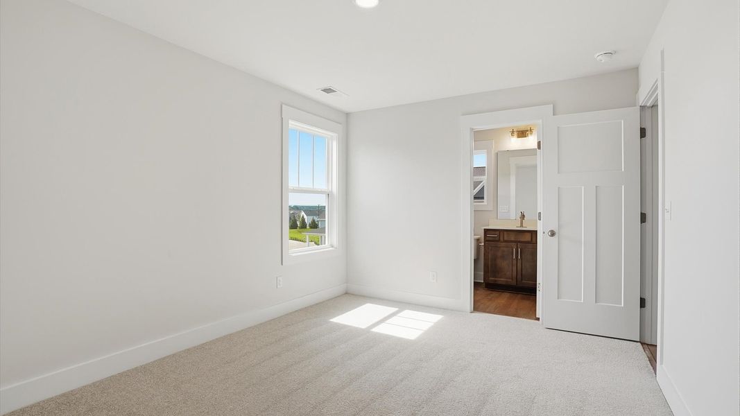 Refined bedroom design with a large window for daylight-filled mornings and peaceful views in Woodruff, SC Refined bedroom design with a large window for daylight-filled mornings and peaceful views in Woodruff, SC