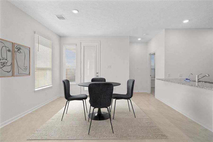 Start your day off right with a cup of coffee sitting with your family in the lovely breakfast/dining area! Featuring large windows with blinds, custom neutral paint, tile flooring, recessed lighting and high ceilings!