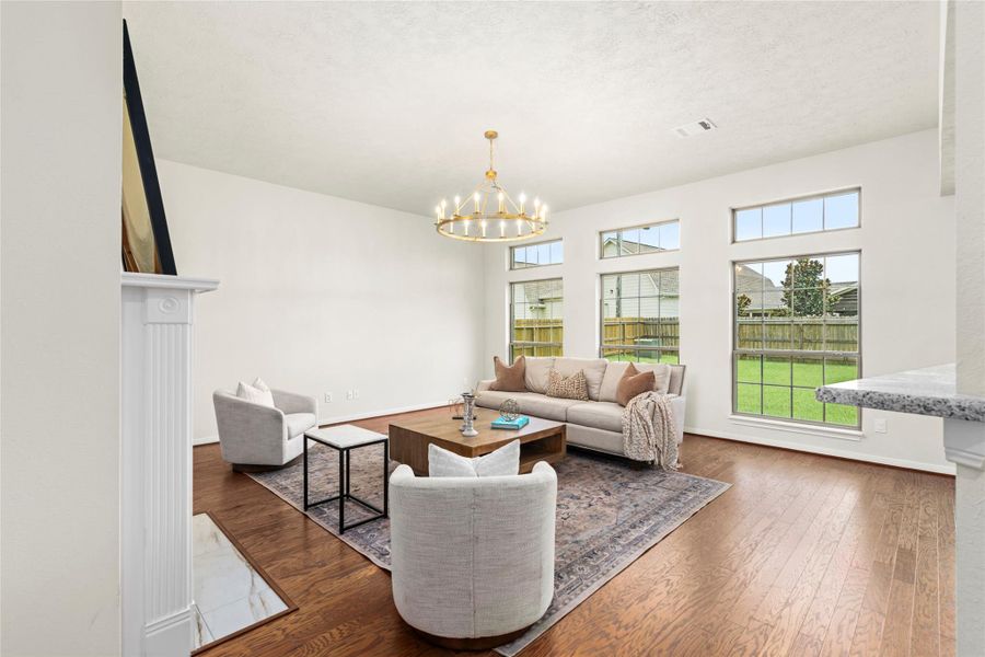Bright formal living room with a classic chandelier — open sightlines highlight the thoughtful floor plan design. Bright formal living room with a classic chandelier — open sightlines highlight the thoughtful floor plan design.
