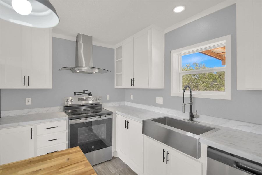 Crisp white cabinetry pairs beautifully with stone countertops and a modern farmhouse sink.
