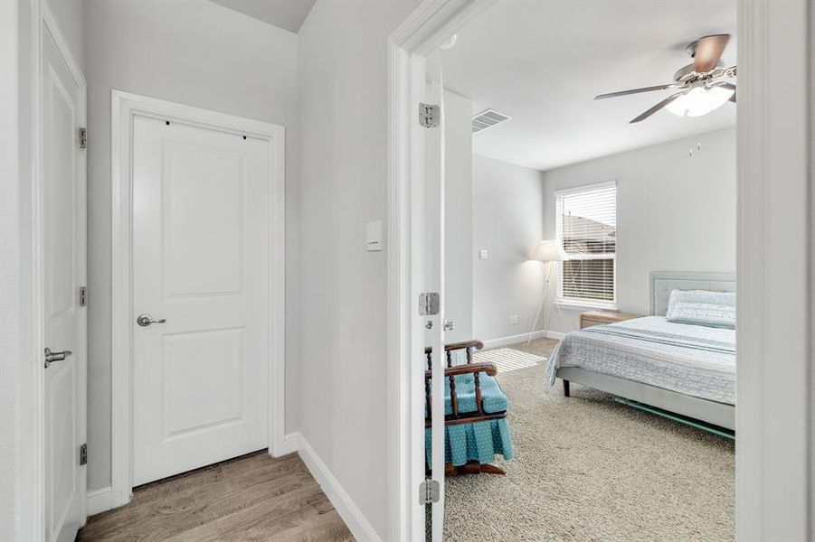 Carpeted bedroom featuring ceiling fan and wood finished floors