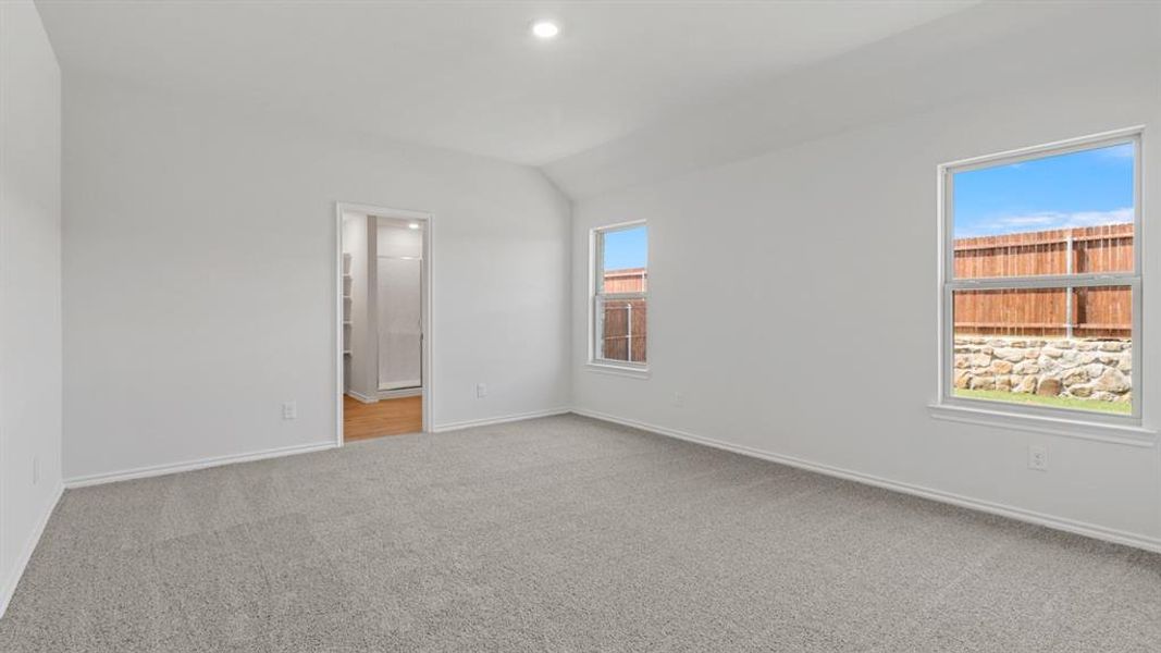 Unfurnished bedroom with light colored carpet, lofted ceiling, and recessed lighting