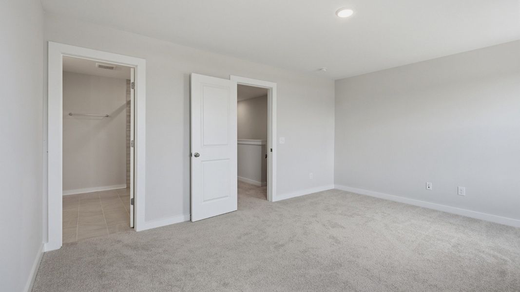 Spacious primary bedroom with connected bathroom and walk-in closet
