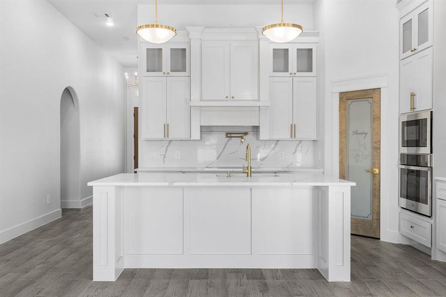 Kitchen with pendant lighting, a center island with sink, sink, and appliances with stainless steel finishes