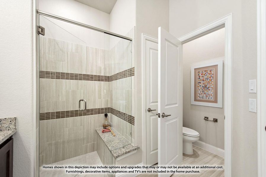 Bathroom with glass walk-in shower, tile walls, built-in bench, and separate water closet with toilet visible through doorway. Bathroom with glass walk-in shower, tile walls, built-in bench, and separate water closet with toilet visible through doorway.