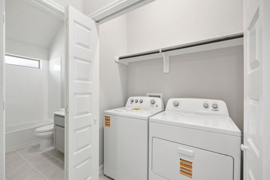 Laundry area featuring washing machine and dryer and light tile patterned flooring