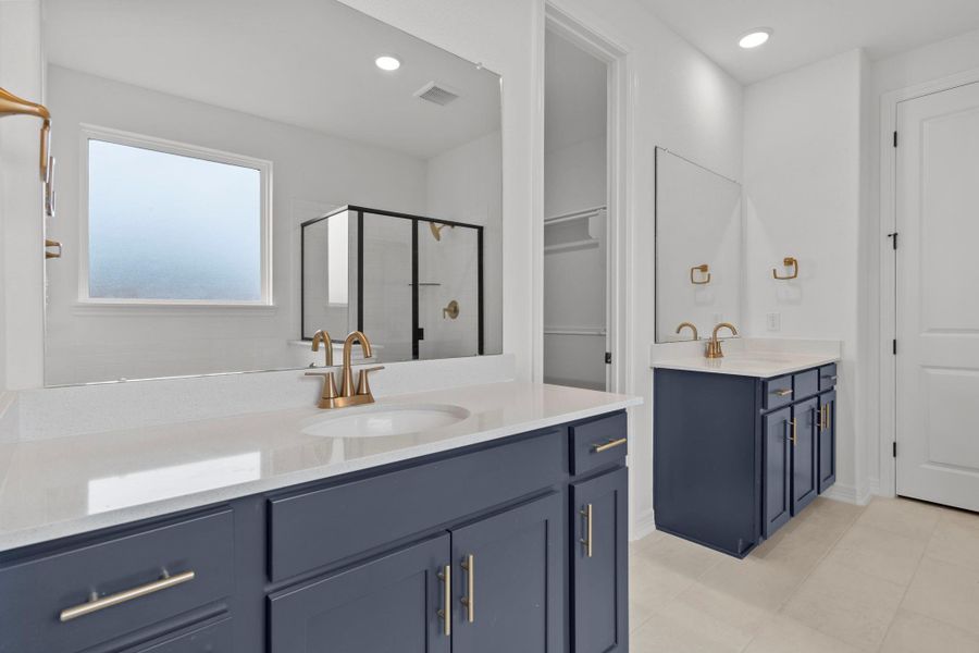 The en-suite bathroom offers a spa-like atmosphere with its elegant design, high end finishes, and tasteful lighting, creating a retreat within your own home.
