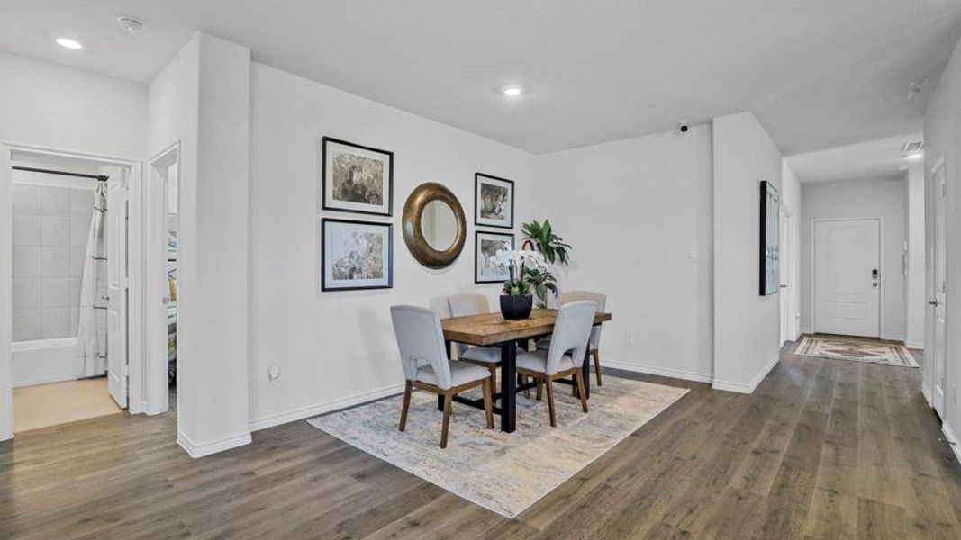 Dining room with dark wood-type flooring and recessed lighting