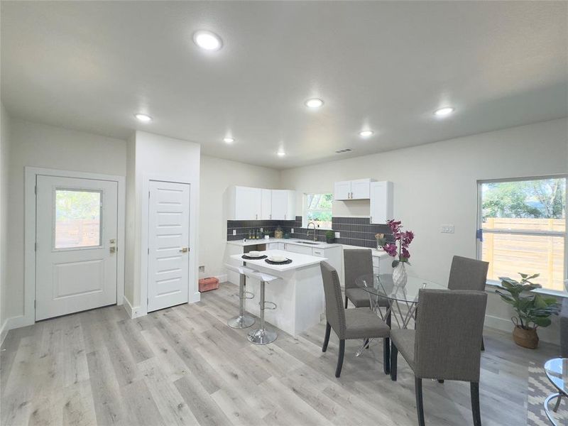 Kitchen with white cabinetry, a kitchen island, a healthy amount of sunlight, and sink