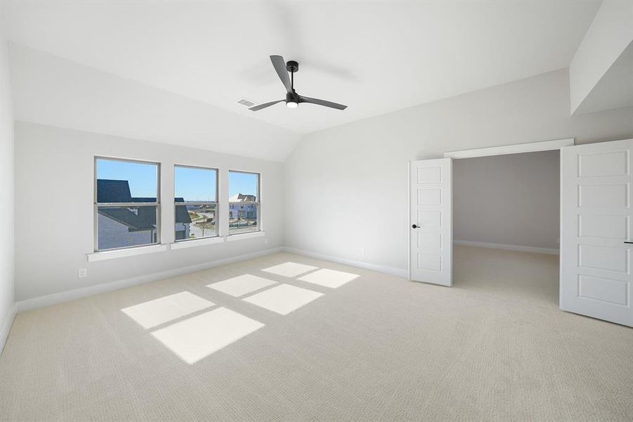 Unfurnished bedroom featuring lofted ceiling, light colored carpet, and ceiling fan Unfurnished bedroom featuring lofted ceiling, light colored carpet, and ceiling fan