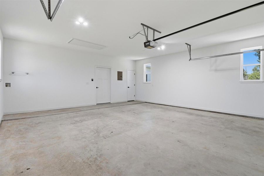 Spacious garage with light concrete flooring and bright white walls Spacious garage with light concrete flooring and bright white walls