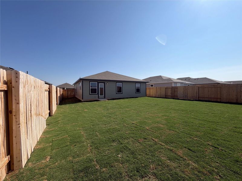 Rear view of house with a fenced backyard