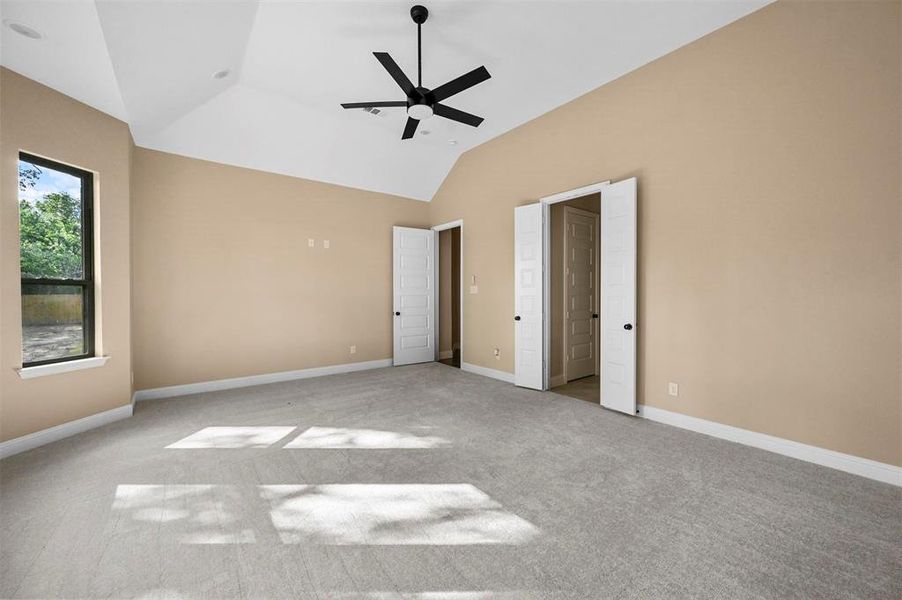 Unfurnished bedroom with lofted ceiling, light colored carpet, and ceiling fan