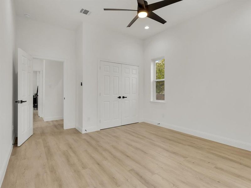 Unfurnished bedroom with ceiling fan, a closet, and light hardwood / wood-style floors