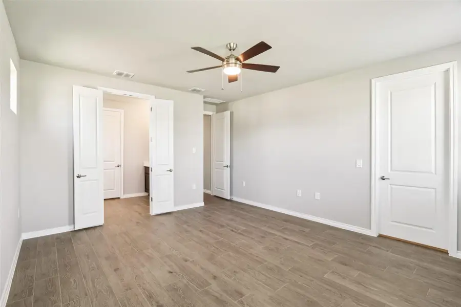 Unfurnished bedroom featuring wood finished floors and a ceiling fan