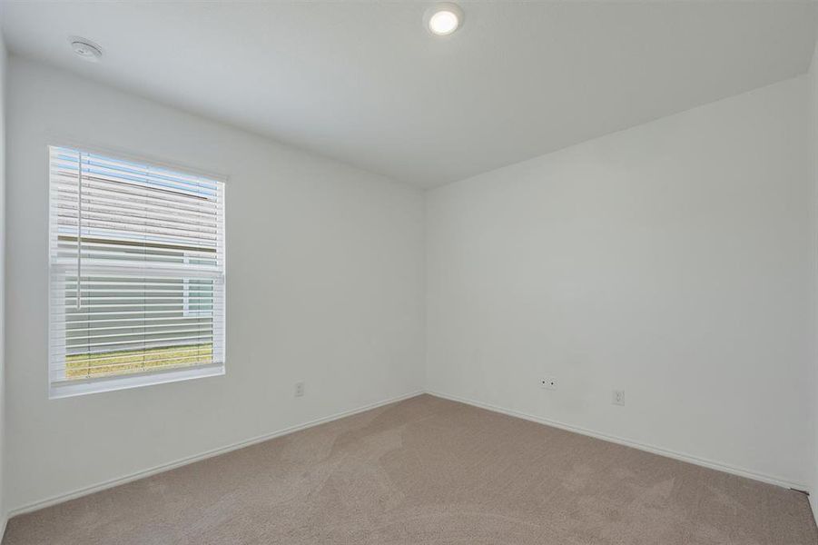 Neutral interior space featuring light-colored carpet, white walls, and a single window with blinds