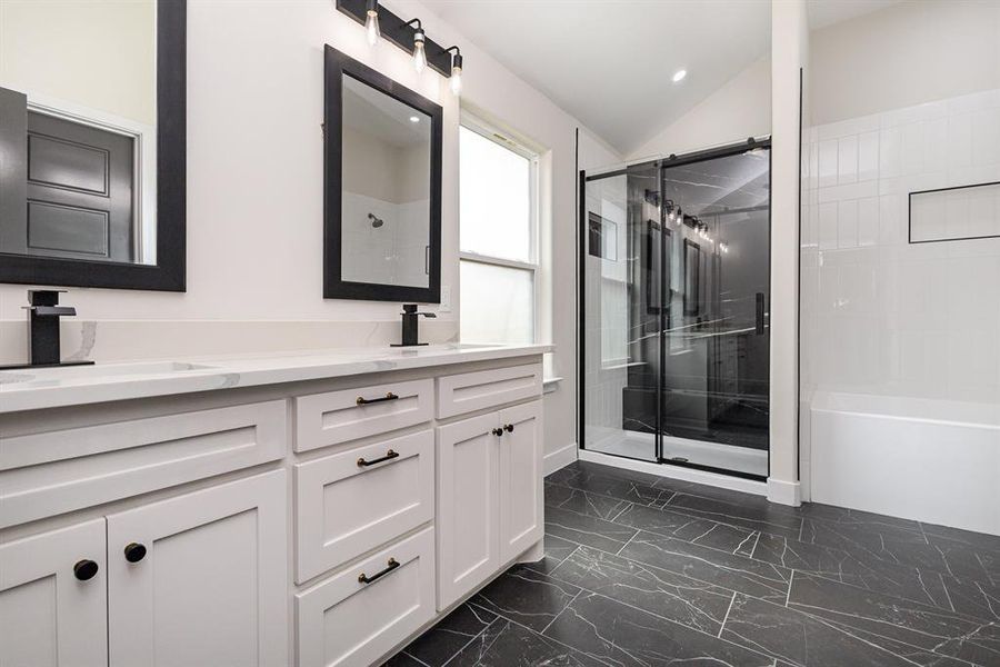 Bathroom featuring a sink, marble finish floor, a stall shower, and double vanity