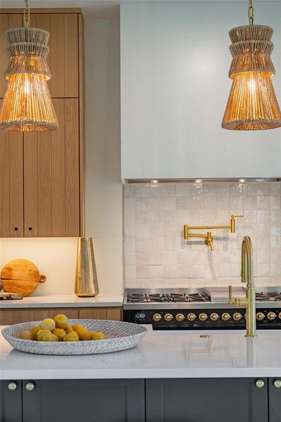 Kitchen featuring stainless steel stovetop, range hood, and tasteful backsplash