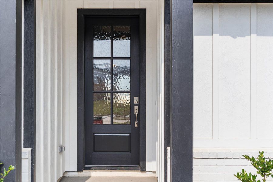 Exceptional curb appeal defines this residence. It features a bold matte black six-lite door with glass panes making it the focal point for this modern farmhouse entryway.