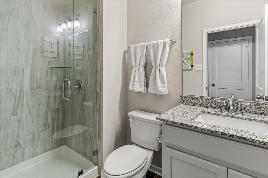 A well-appointed bathroom features a spacious walk-in shower and an elegant granite vanity. A well-appointed bathroom features a spacious walk-in shower and an elegant granite vanity.