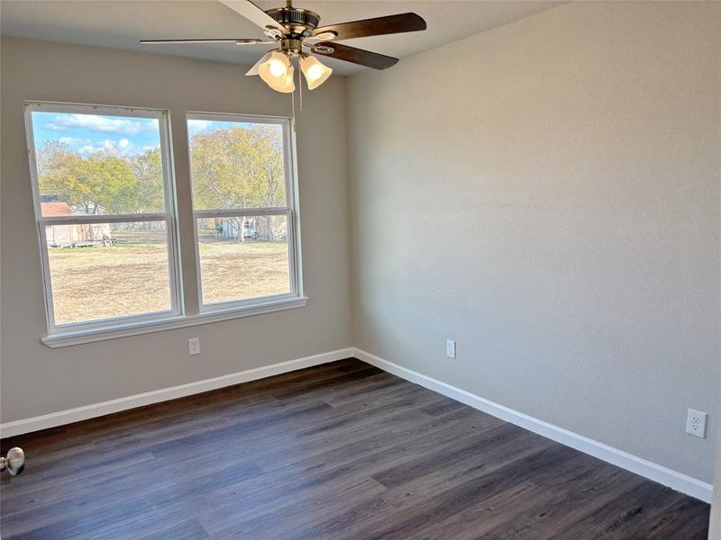 Spare room featuring dark wood-style floors and a ceiling fan