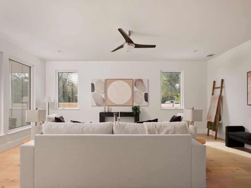 Living area with light wood-type flooring and a ceiling fan Living area with light wood-type flooring and a ceiling fan