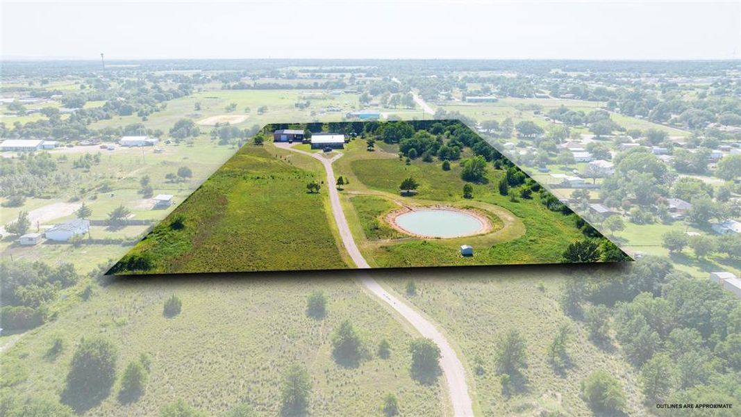 Expansive acreage featuring a private pond, multiple structures, established trees, and a winding driveway Expansive acreage featuring a private pond, multiple structures, established trees, and a winding driveway