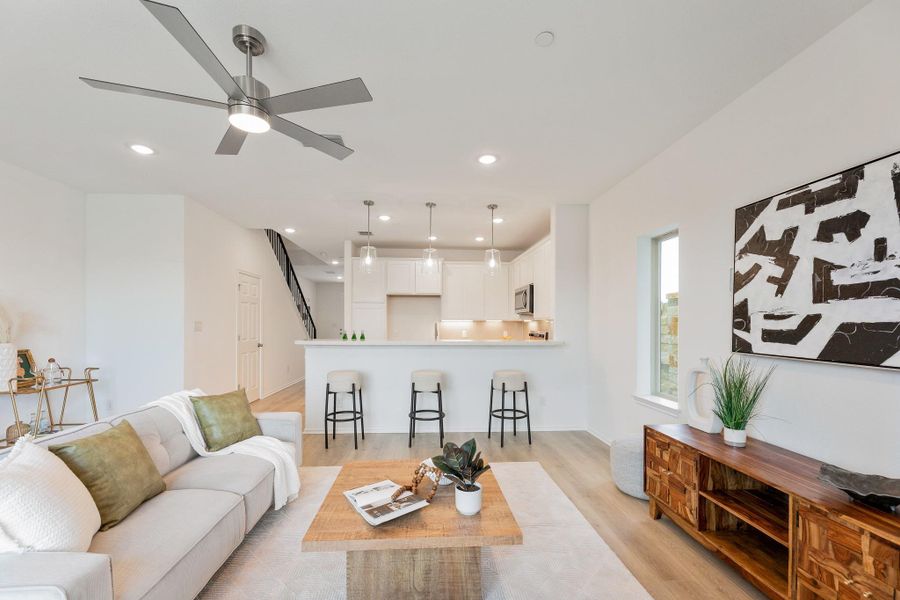 Living room with light wood-style flooring, a ceiling fan, and recessed lighting