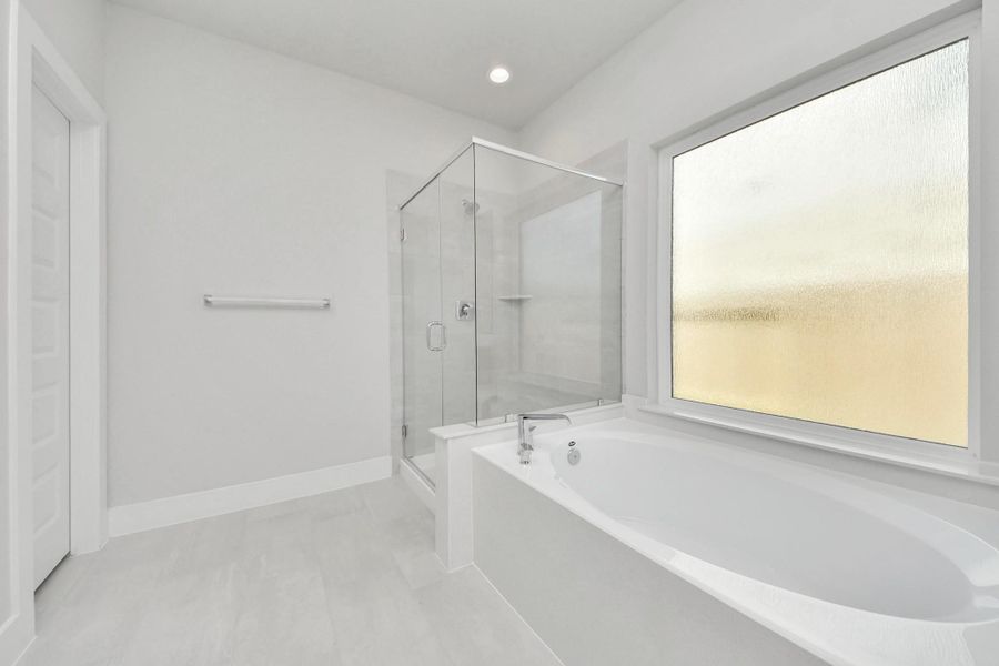 Indulge in a spa-like retreat within the confines of this primary bathroom. Delight in a spacious walk-in shower enveloped in stylish tile surround, unwind in a separate garden tub adorned with custom detailing.