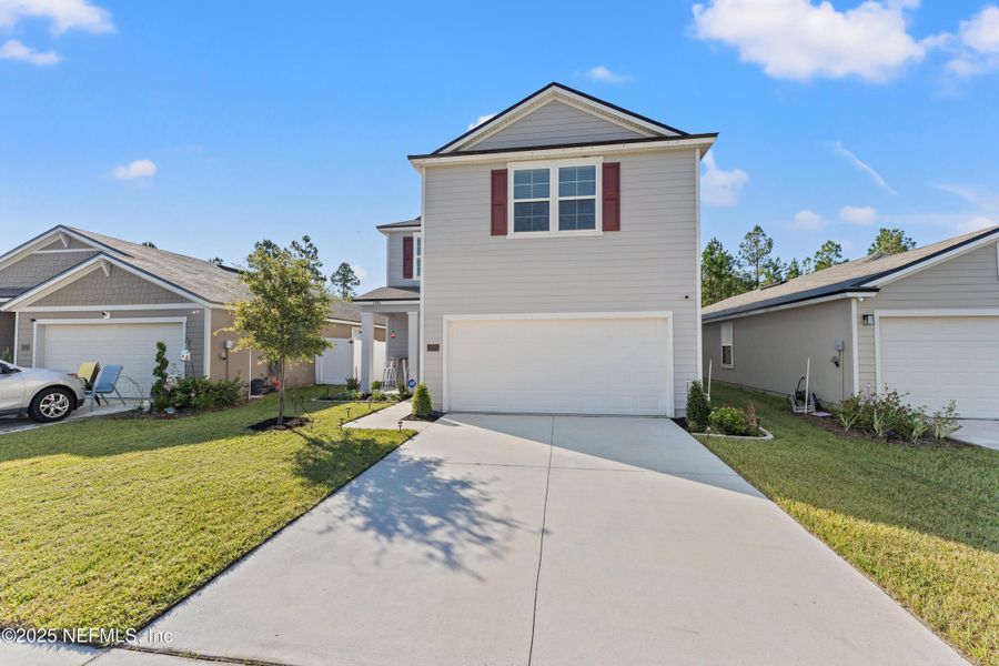Front exterior of a new home in Cross Creek Express, Green Cove Springs, FL, highlighting curb appeal (Image 1).