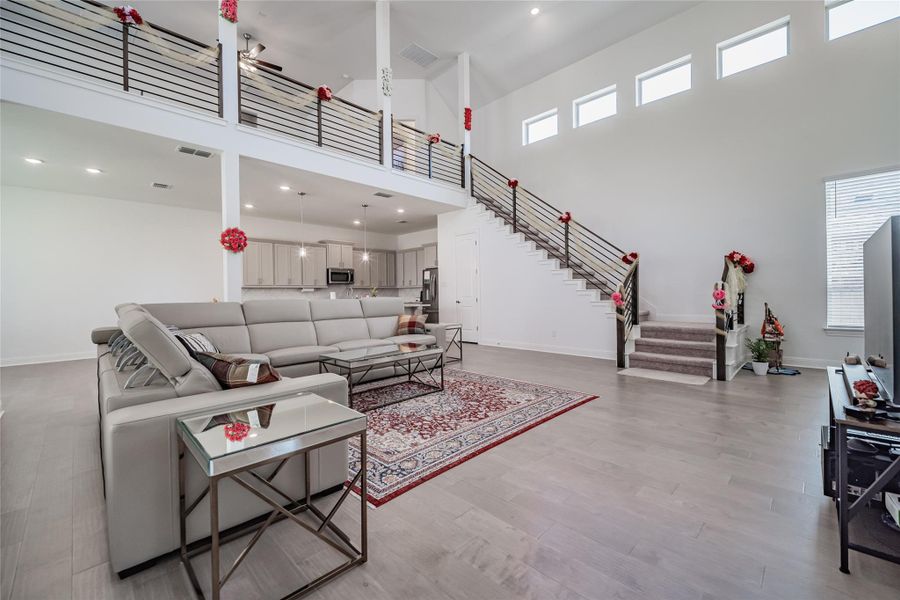 A grand living area boasts soaring ceilings and an elegant open-concept design, perfect for entertaining.