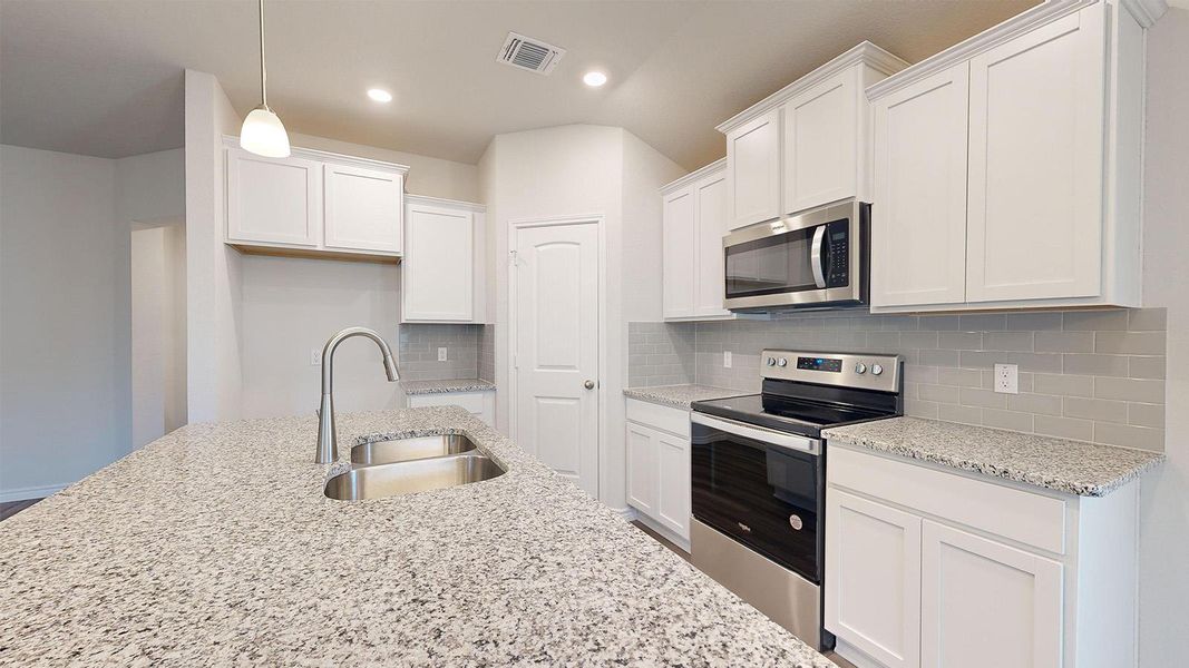 Kitchen with stainless steel appliances, light stone counters, white cabinets, pendant lighting, and tasteful backsplash Kitchen with stainless steel appliances, light stone counters, white cabinets, pendant lighting, and tasteful backsplash