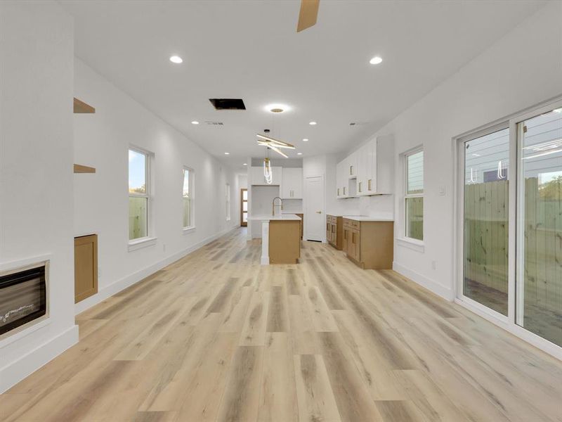 Unfurnished living room with light hardwood / wood-style flooring, ceiling fan, a healthy amount of sunlight, and sink