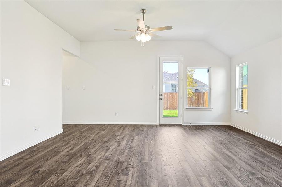 Unfurnished room featuring lofted ceiling, ceiling fan, and dark hardwood / wood-style flooring